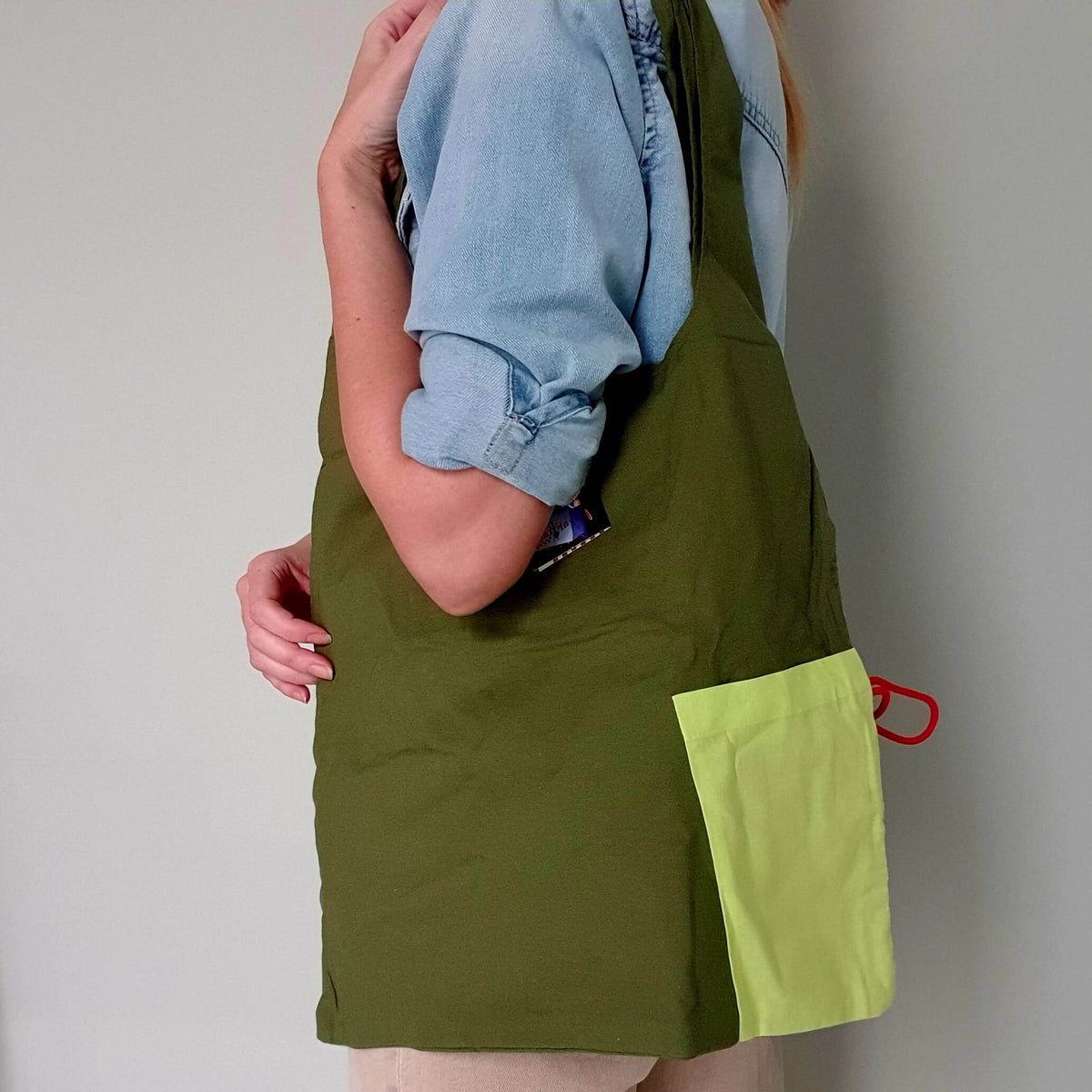 Origami Bag από οργανικό βαμβάκι σε olive green και apple green, φορεμένη στον ώμο.