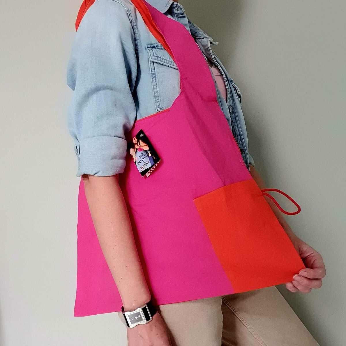 Origami Bag από οργανικό βαμβάκι σε pink και orange, επαναχρησιμοποιούμενη τσάντα αγορών φορεμένη στον ώμο.